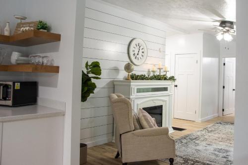 a living room with a fireplace and a clock on the wall at Maple Retreat with Big Pool in Dundee
