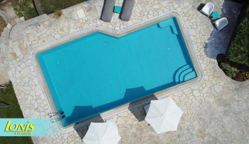 an overhead view of a swimming pool on a stone floor at Ionis Studios in Lefkada