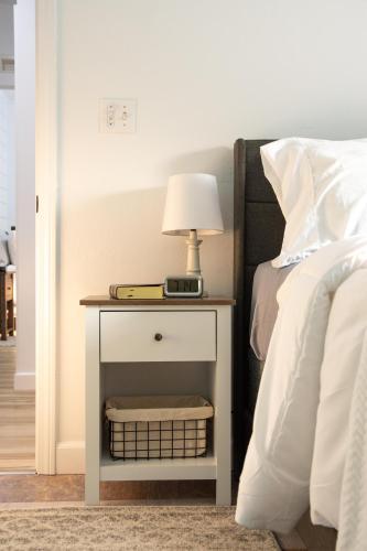 a bedside table with a lamp on it next to a bed at Maple Retreat with Big Pool in Dundee
