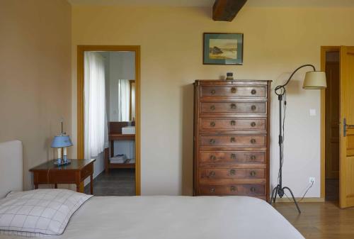 a bedroom with a dresser and a bed and a dresser at La Maison de Charlotte in Doudeville