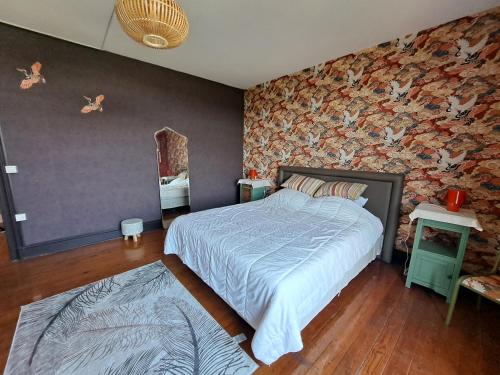 a bedroom with a bed and a wall with birds on it at Aux alouettes in Landelies