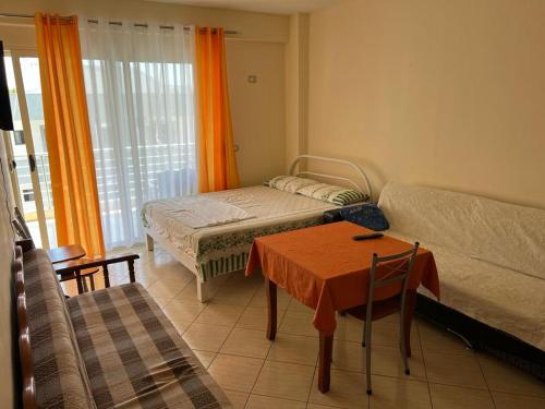 een kamer met een bed, een tafel en een bank bij Rexhina Apartments in Durrës