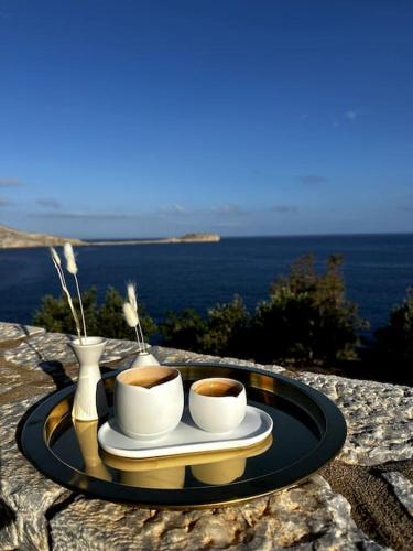 a tray with two cups of coffee on a table at Cozy Cliff Tower w/ Breathtaking Sea Views in Áyios Yeóryios