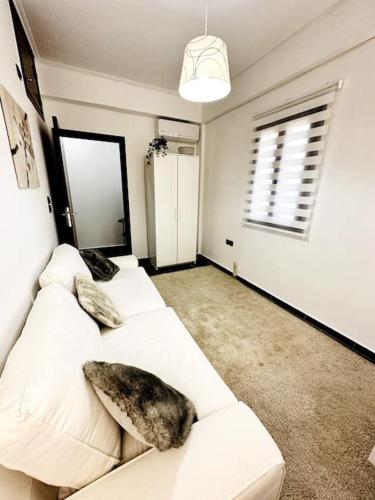 a living room with two white couches and a window at Cozy Cliff Tower w/ Breathtaking Sea Views in Áyios Yeóryios