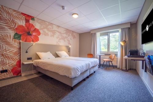 ロヘムにあるFletcher Hotel-Restaurant De Scheperskampのベッドとテレビが備わるホテルルームです。