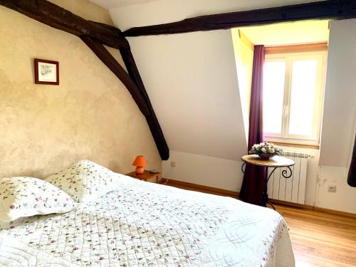ein Schlafzimmer mit einem weißen Bett und einem Fenster in der Unterkunft Gîte à la Ruelle "Pierre et Mamie" ! in Savignac-de-Miremont