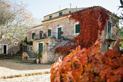 an old stone house with red ivy on it at Agriturismo Bannata in Piazza Armerina
