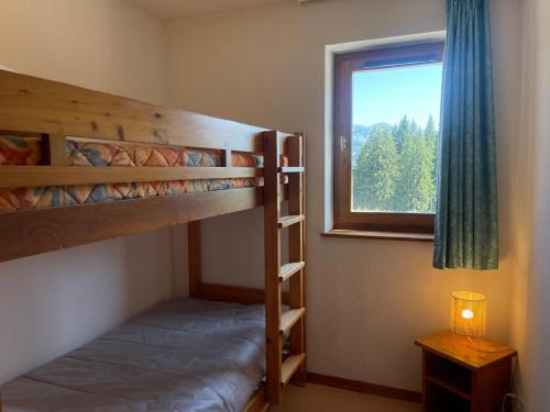 a bedroom with two bunk beds and a window at Appartement Morillon 1100, 2 pièces, 7 personnes - FR-1-624-100 in Morillon