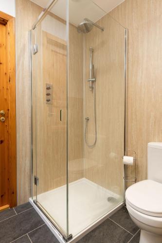 a shower with a glass door in a bathroom at Langrick in Nethy Bridge