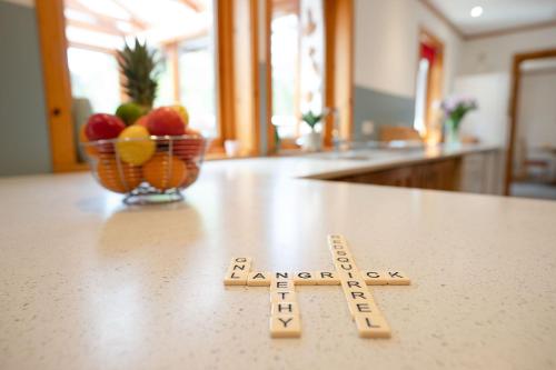 a kitchen counter with two wooden markers on a counter with a bowl of fruit at Langrick in Nethy Bridge