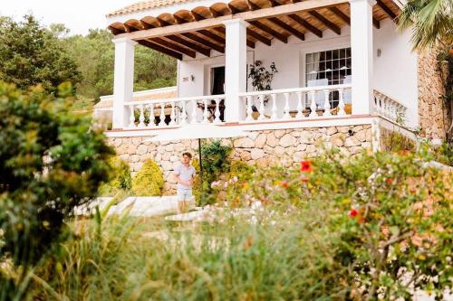 Eine Frau steht auf einem Balkon eines Hauses in der Unterkunft Villa B&M Experience in Sant Francesc de s'Estany