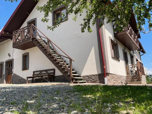 um edifício com escadas e um banco em frente em Smerichka em Bukovel