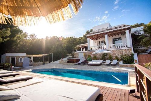 uma villa com piscina em frente a uma casa em Villa B&M Experience em Sant Francesc de s'Estany
