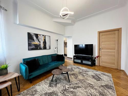 un soggiorno con divano verde e TV a schermo piatto di City View - Luxury Apartment - Sanador Victoriei a Bucarest