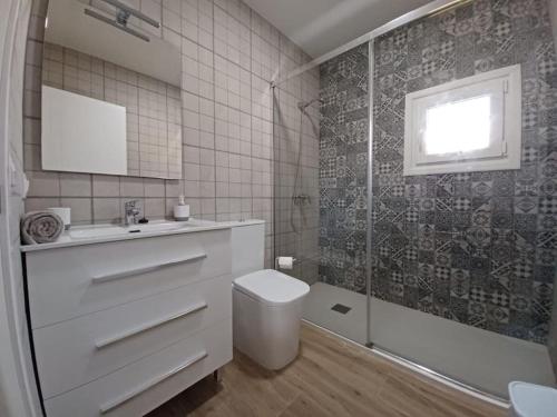 y baño con aseo, lavabo y ducha. en Casa vacacional en Chiclana de la Frontera, en Chiclana de la Frontera