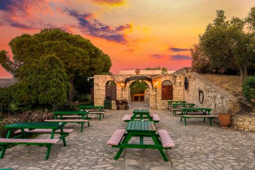 a group of picnic tables with a sunset in the background at Labranda Ephesus Princess - All Inclusive in Kusadası
