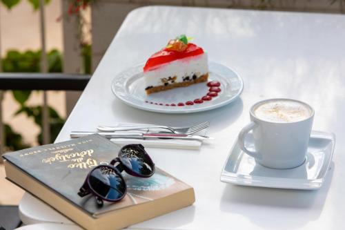 a table with a slice of cake and a cup of coffee at Labranda TMT Bodrum in Bodrum City