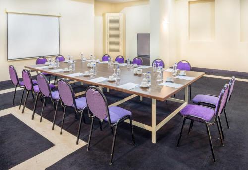 a conference room with a long table and purple chairs at Labranda Ephesus Princess - All Inclusive in Kusadası