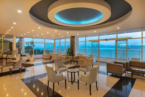 a lobby with chairs and tables and a blue ceiling at Labranda Ephesus Princess - All Inclusive in Kusadası