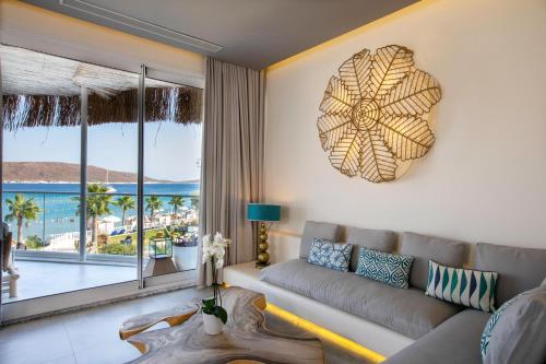 a living room with a couch and a large window at Design Plus Seya Beach Hotel in Alacati