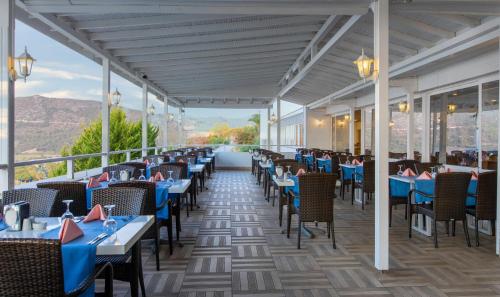 a restaurant with blue tables and chairs with a view at Labranda Ephesus Princess - All Inclusive in Kusadası