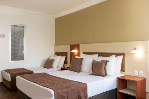 a hotel room with two beds and a window at Labranda Ephesus Princess - All Inclusive in Kusadası