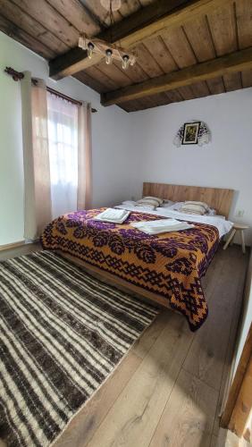 Bett in einem Zimmer mit einem Teppich auf dem Boden in der Unterkunft Casa cu Lavanda in Petroşani