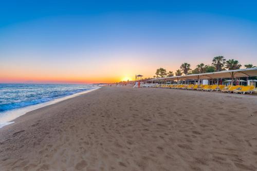 a beach with a bunch of chairs and the ocean at Asteria Collection Side in Side