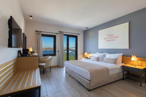 a hotel room with a large bed and a desk with a desk at Senses Hotel - Adults Only in Bodrum City