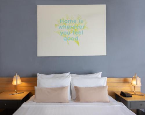 Senses Hotel - Adults Only في بودروم: غرفة نوم بسرير ومخدات وقلب على الحائط