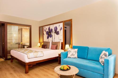 a bedroom with a bed and a blue couch at Aquaworld Belek in Belek