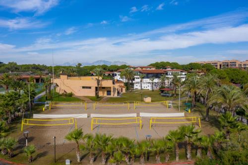 a parking lot with yellow chairs and palm trees at Asteria Family Resort Belek in Belek