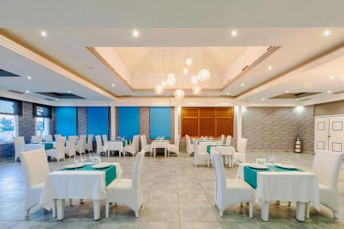 a dining room with white tables and white chairs at Asteria Family Resort Belek in Belek