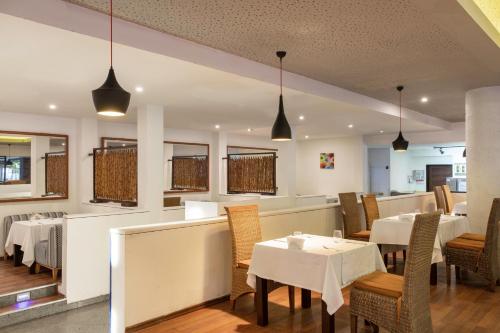 a dining room with tables and chairs and pendant lights at Asteria Family Resort Belek in Belek