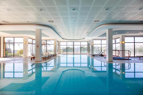 a large swimming pool with blue water in a building at Asteria Family Resort Belek in Belek