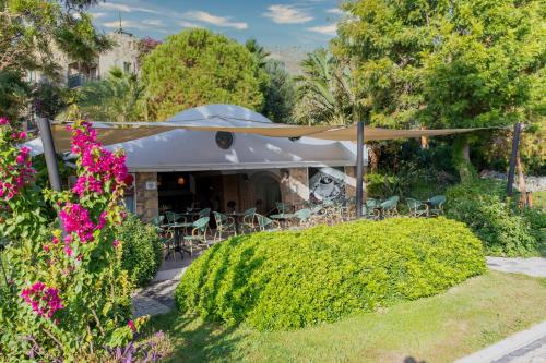 a patio with a table and chairs in a garden at Selectum Collection Bodrum in Akyarlar
