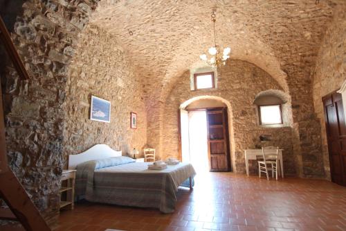 a bedroom with a bed in a stone wall at Dimora Schioppo - Irpinia in Calitri