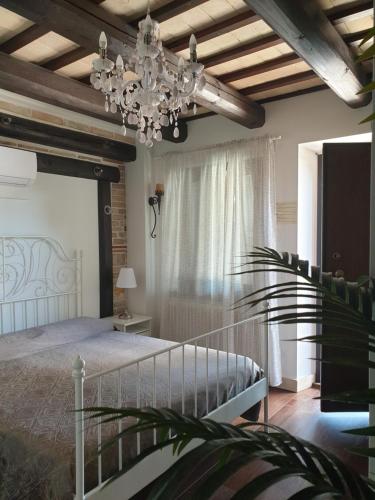 a bedroom with a bed and a chandelier at La Dolce Vita in Castelfidardo