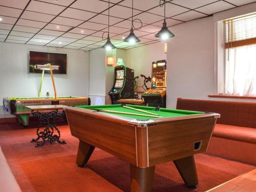 a billiard room with a pool table and several chairs at Granville Hotel in Blackpool