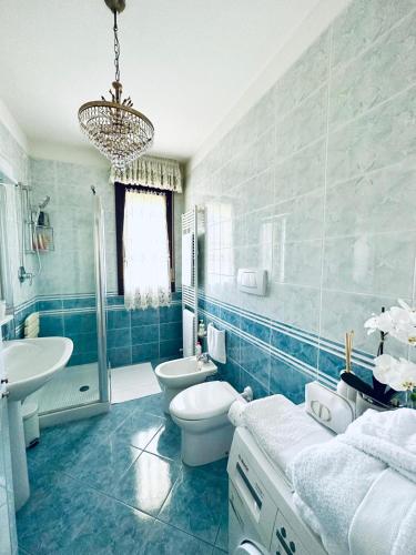 a blue bathroom with a toilet and a sink at Casa di Alice in Parma
