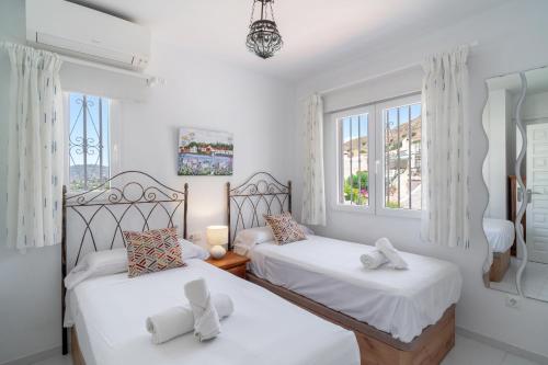 2 camas en una habitación con 2 ventanas en Los Aguacates Bellavista Casasol, en Nerja