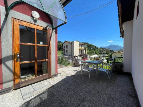 eine Terrasse mit einem Tisch, Stühlen und einer Glastür in der Unterkunft Bliss - Casale della Vite in Magliaso