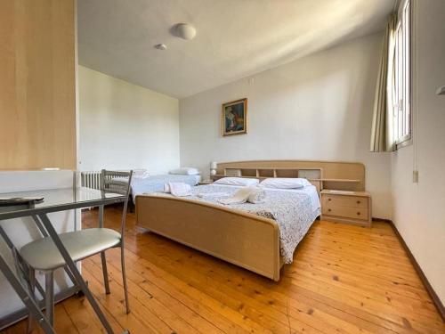 a bedroom with two beds and a table and a desk at Bliss - Casale della Vite in Magliaso