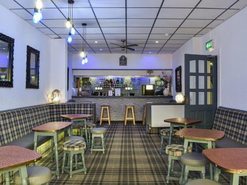 um restaurante com mesas e bancos e um bar em The Danescourt em Blackpool