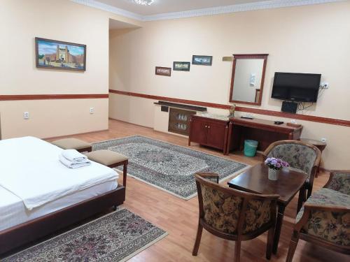 um quarto com uma cama, uma secretária e um espelho em Sarbon Plaza Hotel em Bukhara