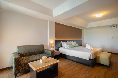 a hotel room with a bed and a couch at Golden Jade Suvarnabhumi in Lat Krabang