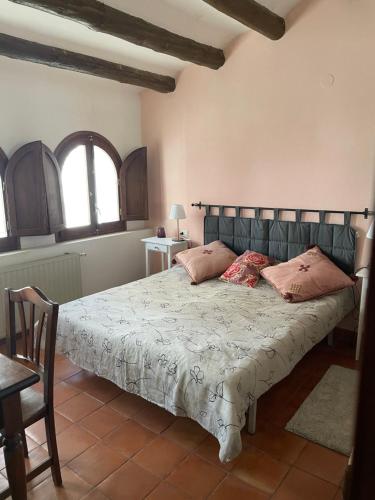 1 dormitorio con 1 cama grande con almohadas rosas en Belmonte, en Belmonte de Mezquín