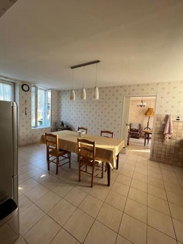 une cuisine et une salle à manger avec une table et des chaises dans l'établissement Maisonnette à l’orée des vignes, à Lye