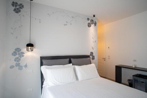 a bedroom with a white bed with white pillows at Fiori di Cardo - Agrimare in Cervia