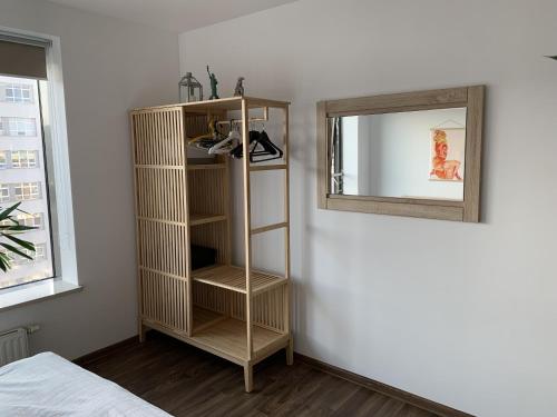 Habitación con estantería junto a un espejo en Apartament Plac Kaszubski, en Gdynia